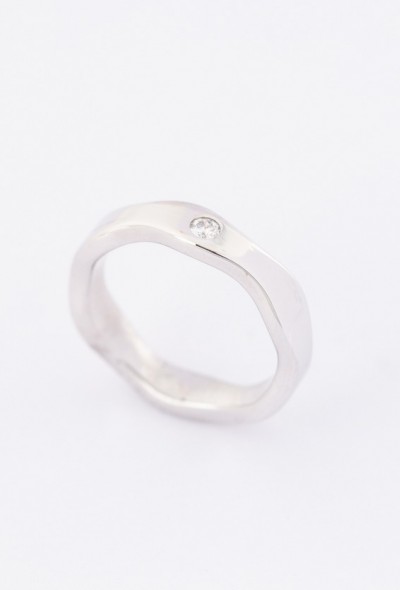 Wit gouden golvende ring met een briljant