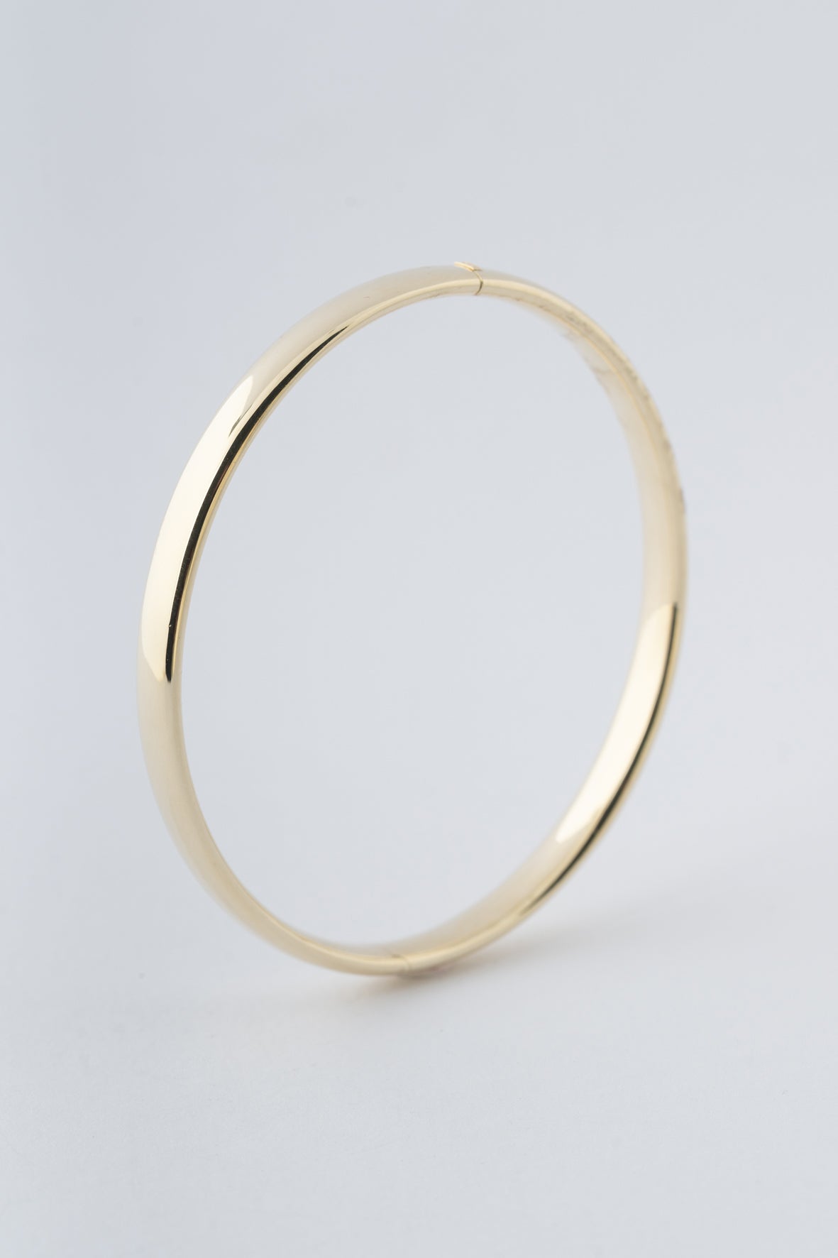 Geel gouden bangle met scharnier sluiting.