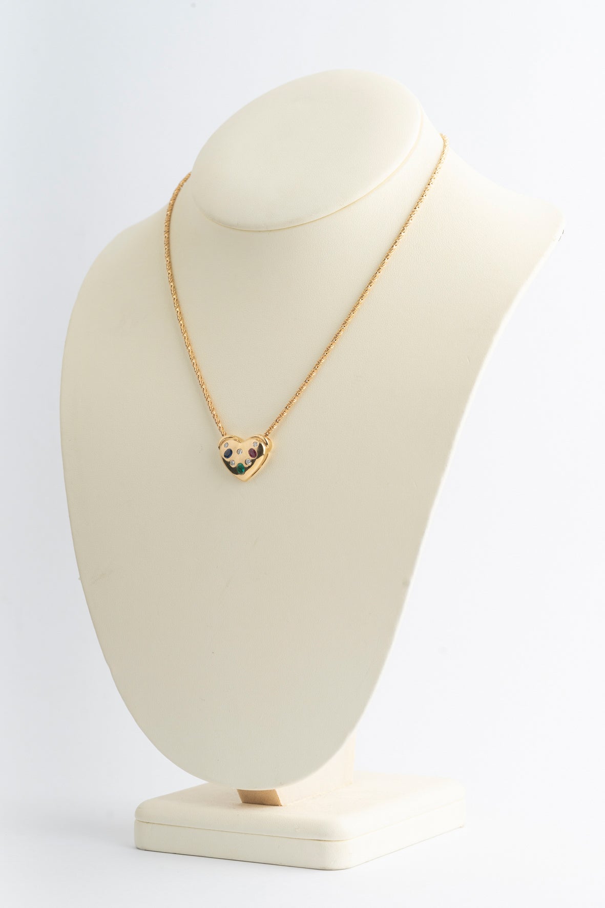 Yellow gold heart with brilliant-cut diamonds, sapphire, ruby, and emerald on a yellow gold cord necklace