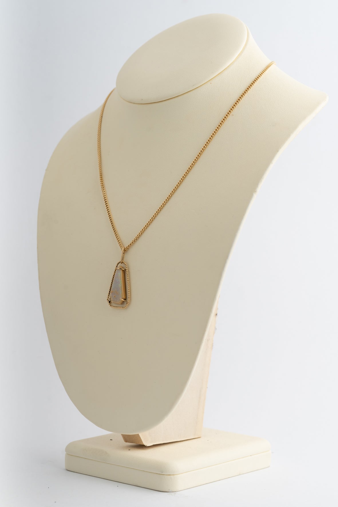 Yellow gold pendant with opal on a yellow gold curb chain
