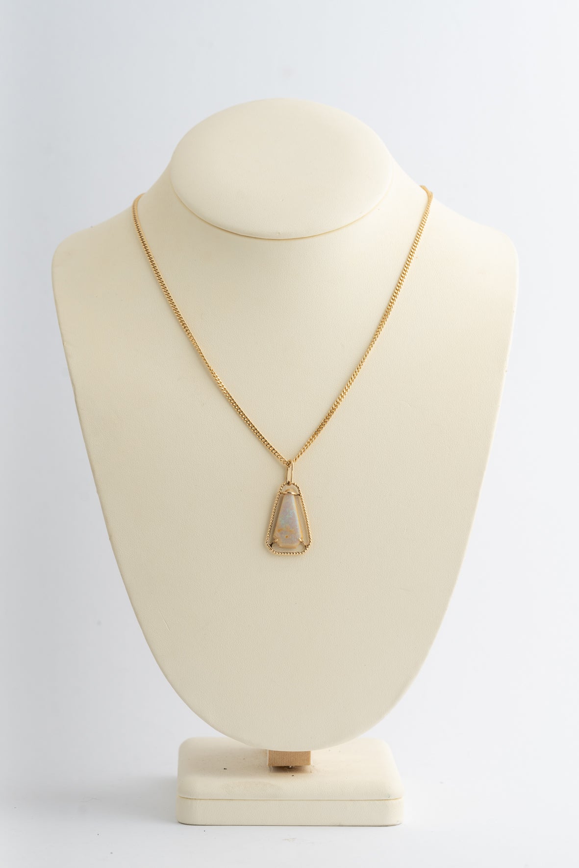 Yellow gold pendant with opal on a yellow gold curb chain