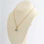 Yellow gold double cluster pendant with emerald and brilliant cut diamonds on a yellow gold necklace