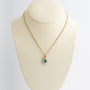 Yellow gold double cluster pendant with emerald and brilliant cut diamonds on a yellow gold necklace