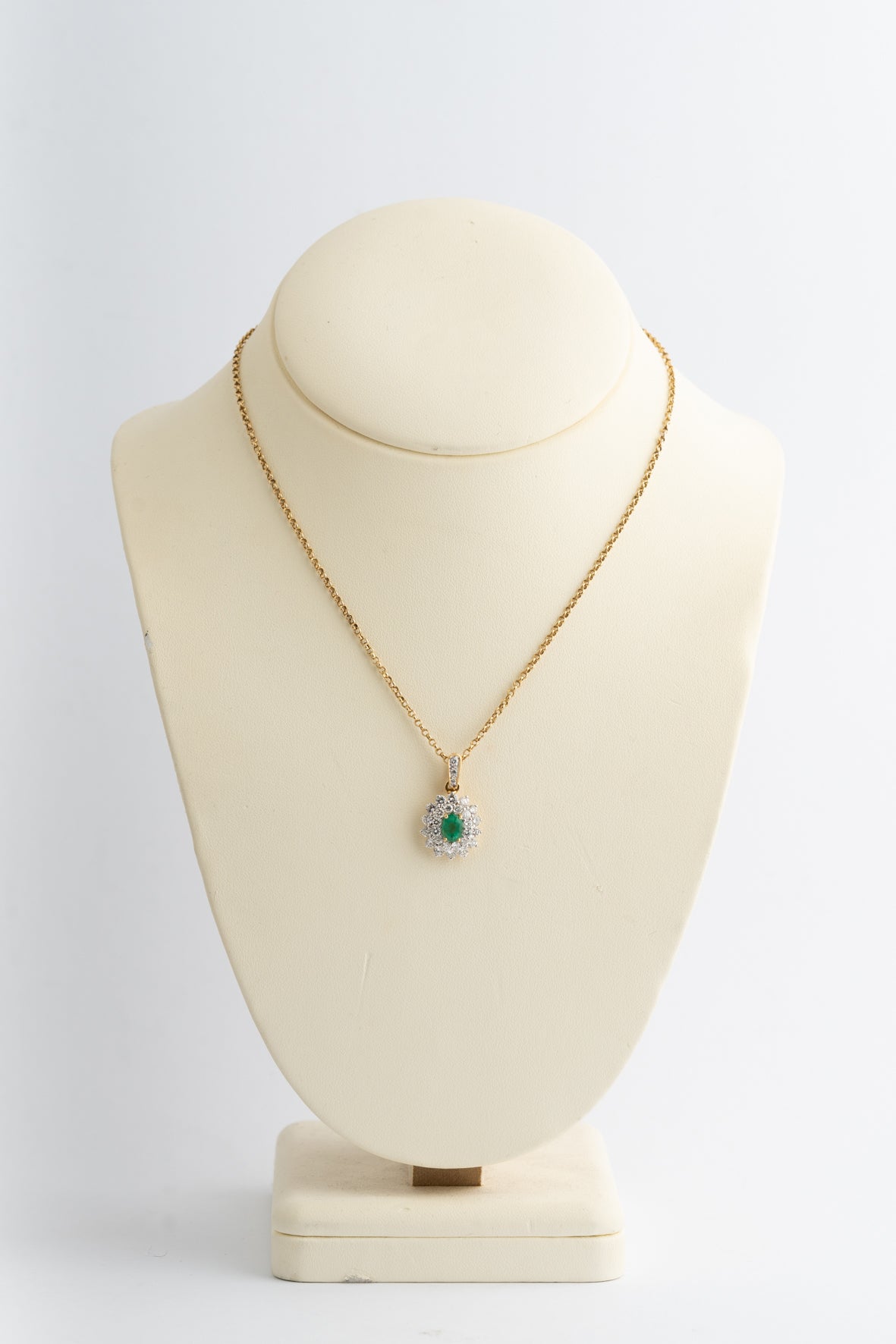 Geel gouden dubbele entourage hanger met smaragd en briljanten aan geel gouden collier