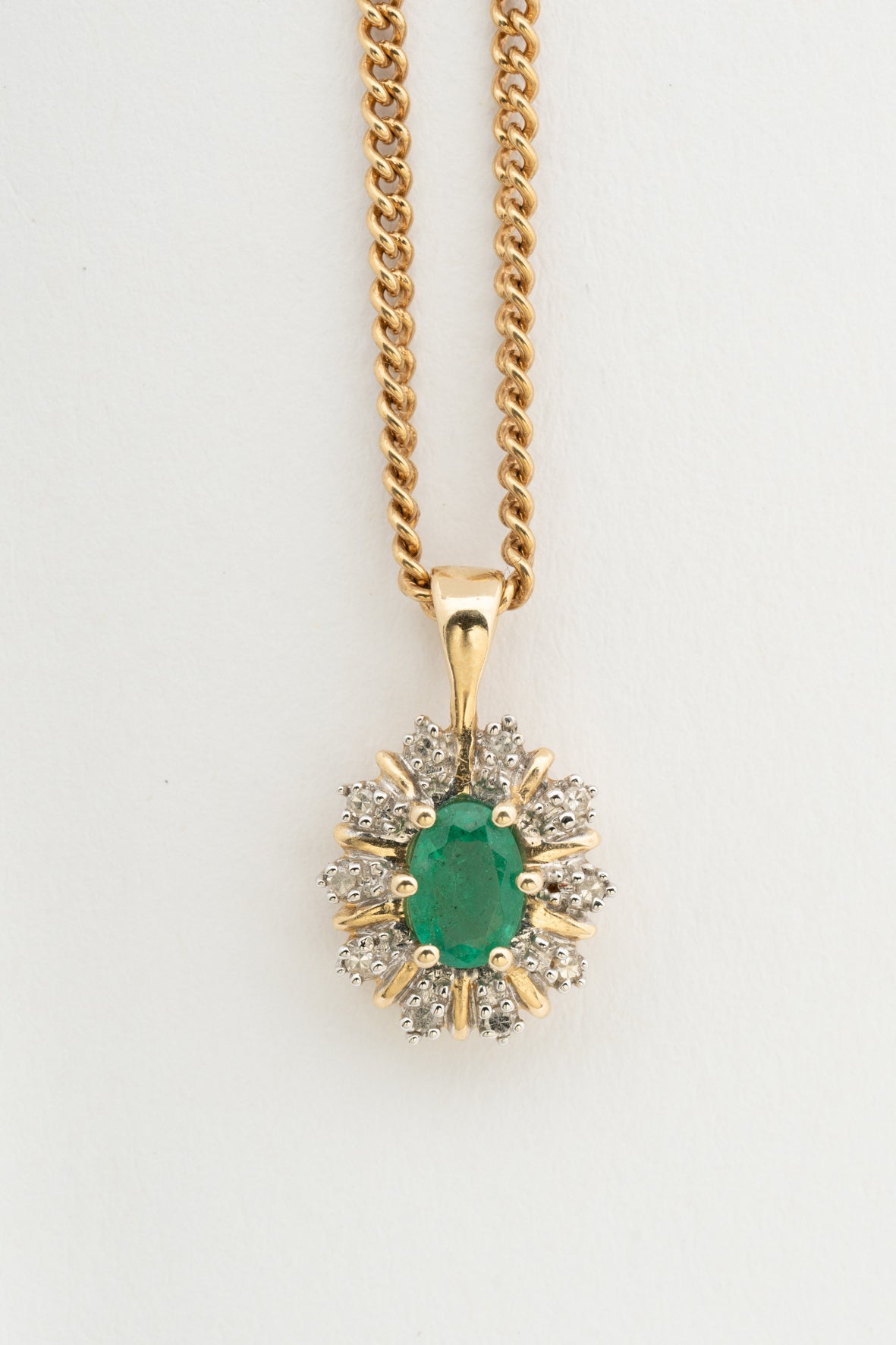Yellow gold entourage pendant with emerald and diamonds on yellow gold gourmet necklace