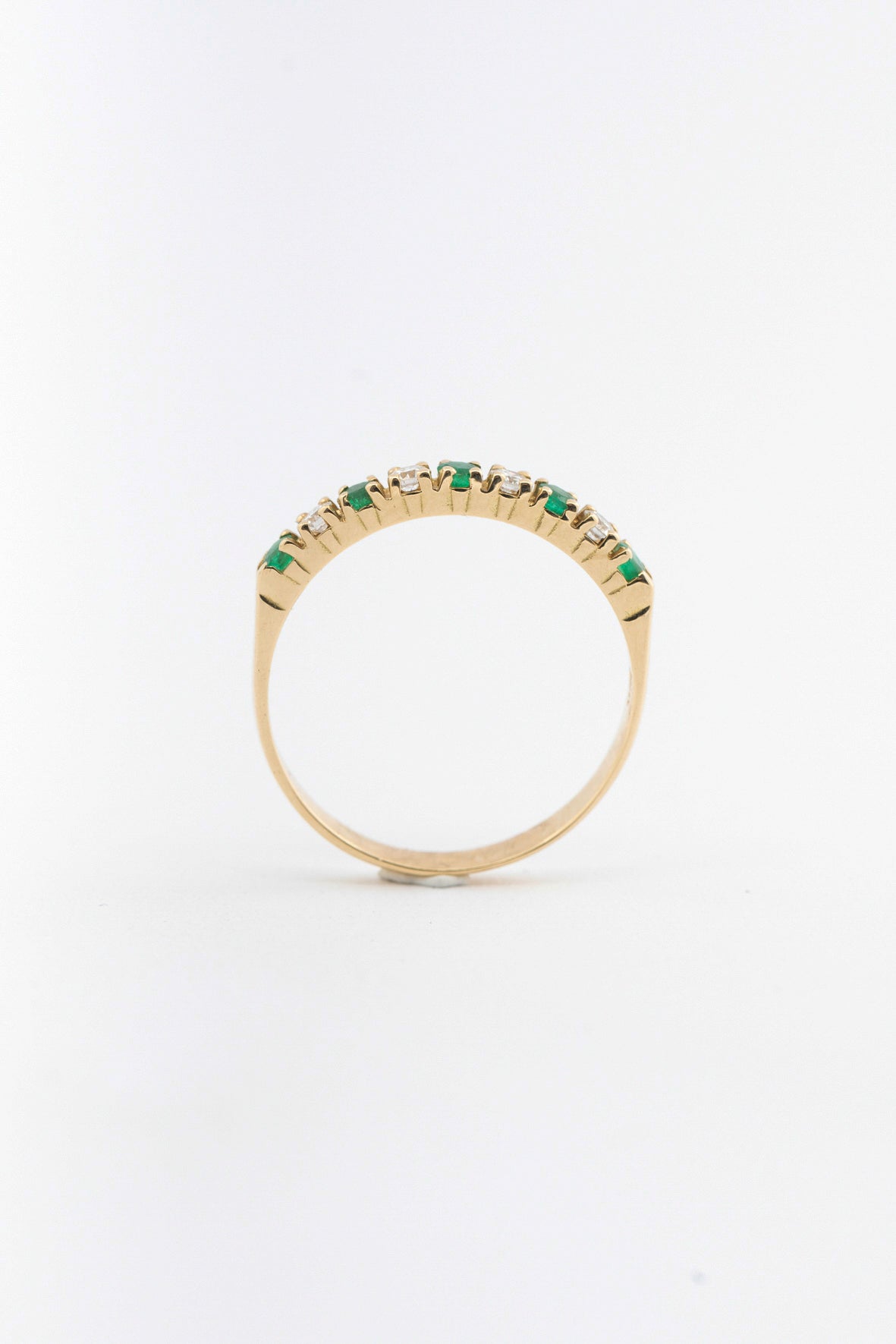 Yellow gold eternity ring with emeralds and brilliant cut diamonds
