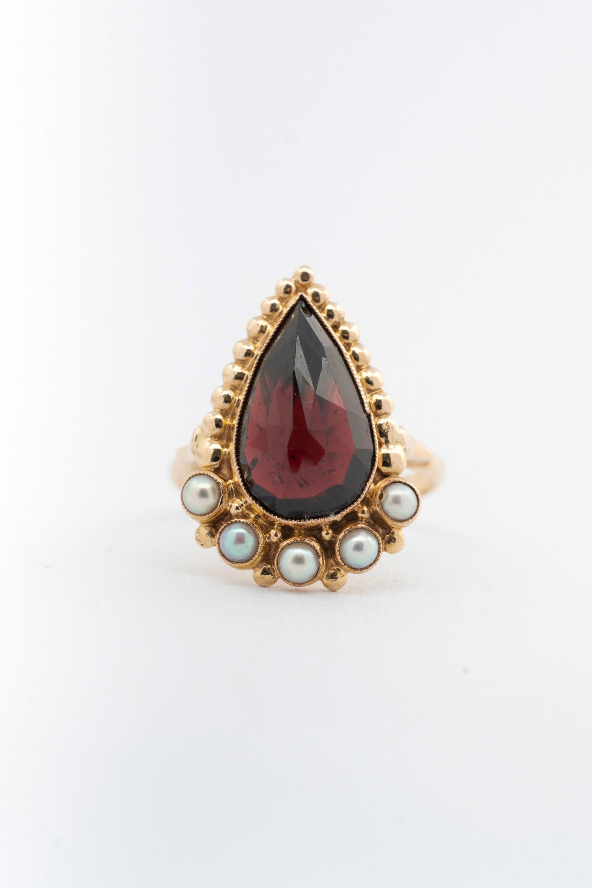 Yellow gold ring with pear-shaped garnet and pearls