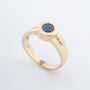 Yellow gold band ring with a sapphire and brilliant-cut diamonds