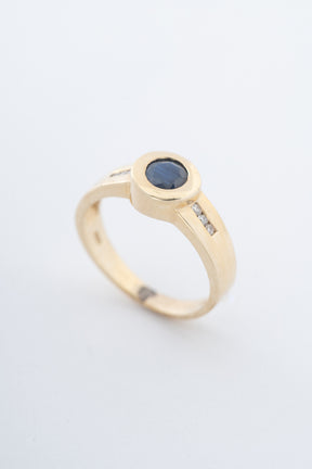 Yellow gold band ring with a sapphire and brilliant-cut diamonds