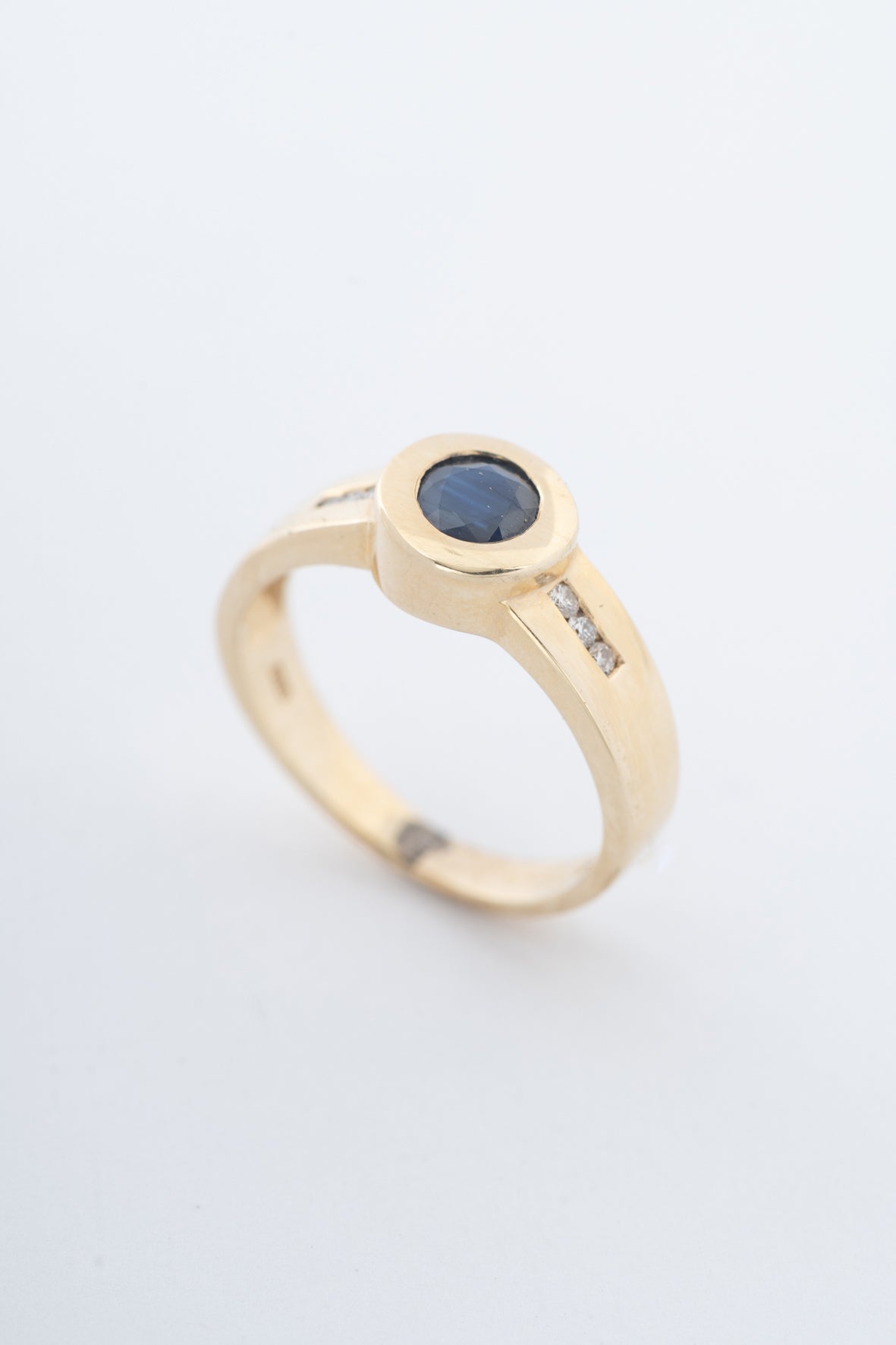 Geelgouden band ring met een saffier en briljanten