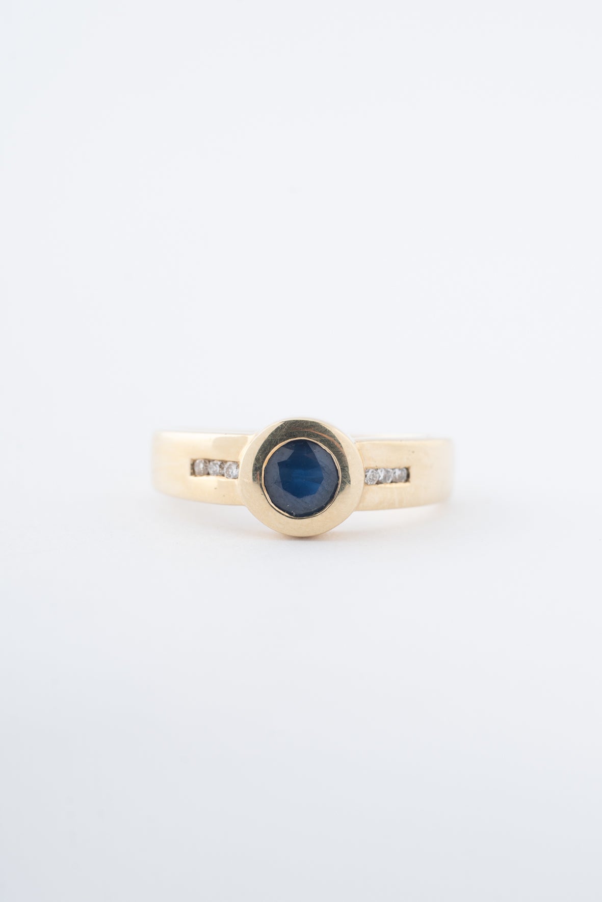 Yellow gold band ring with a sapphire and brilliant-cut diamonds