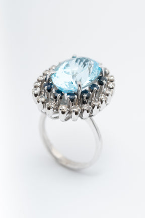 Wit gouden dubbele entourage ring met topaas, saffieren en briljanten.
