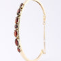 Gold clamp bracelet with garnet