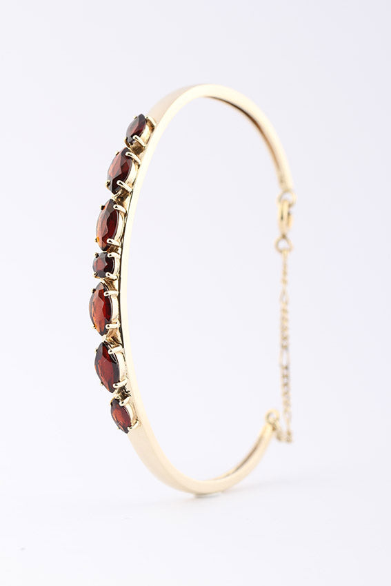 Gold clamp bracelet with garnet