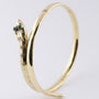 Gold snake slave bracelet with emeralds