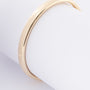 Gold bangle with silver core tube with hinged closure