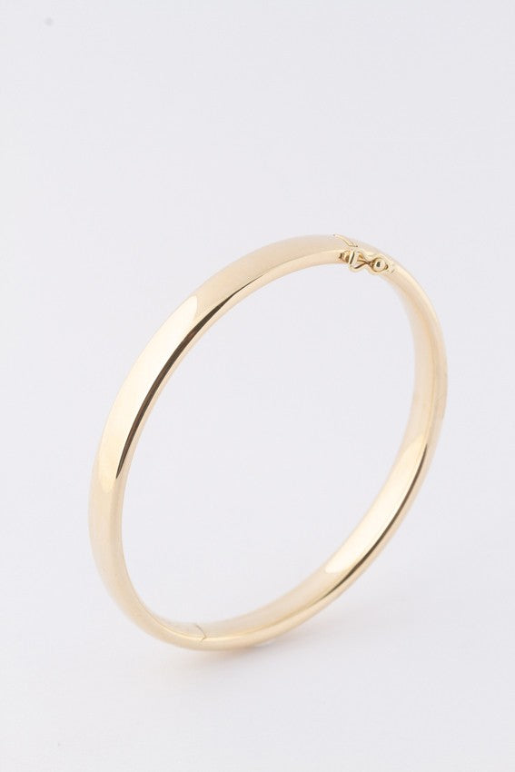 Gold bangle with silver core tube with hinged closure