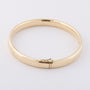 Gold bangle with silver core tube with hinged closure
