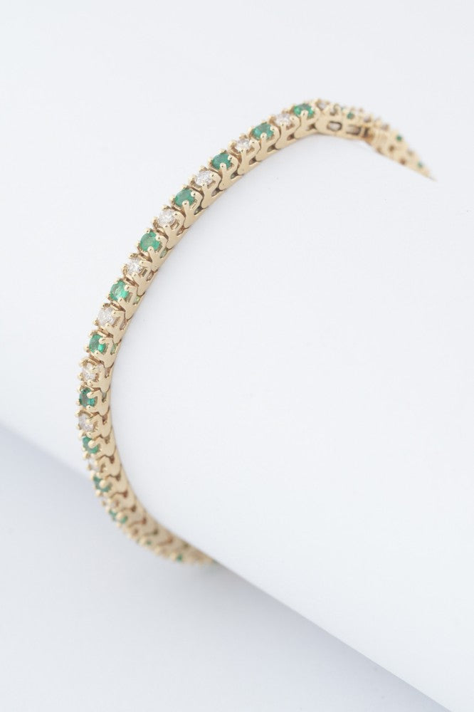 Gold tennis bracelet with emeralds and diamonds