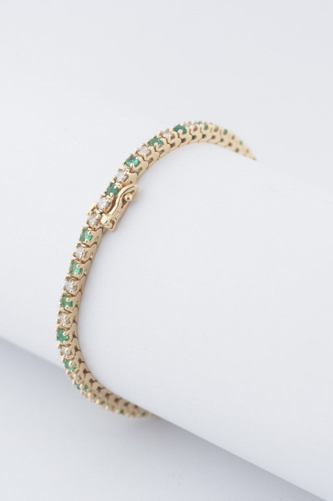 Gold tennis bracelet with emeralds and diamonds