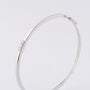 White gold bangle with three brilliant-cut diamonds. Total weight approx. 0.15 ct.