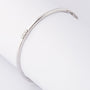 White gold bangle with three brilliant-cut diamonds. Total weight approx. 0.15 ct.