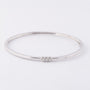 White gold bangle with three brilliant-cut diamonds. Total weight approx. 0.15 ct.