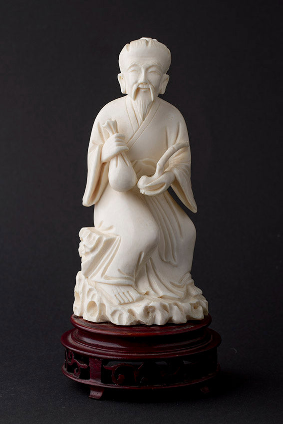 Old ivory sculpture of a man with a money bag and ruji
