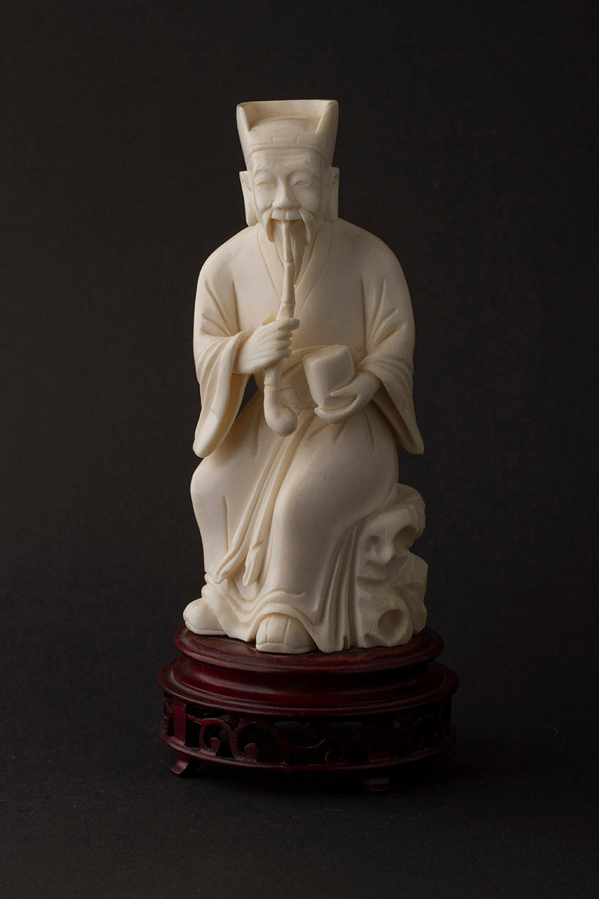 Old ivory sculpture of a man with a pipe