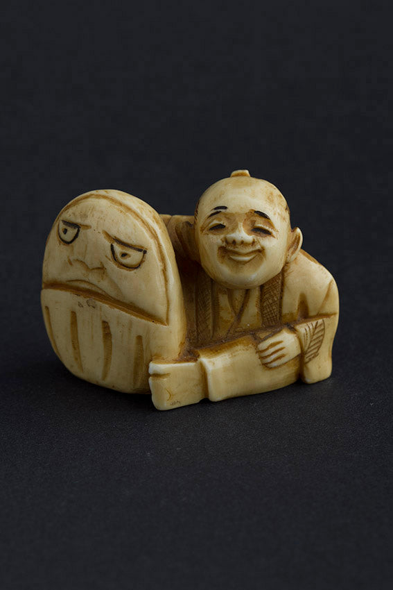 Antique ivory netsuké man with Darma doll