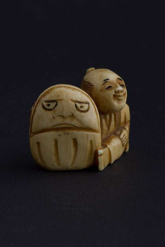 Antique ivory netsuké man with Darma doll