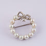 White gold bow brooch with a brilliant and pearls