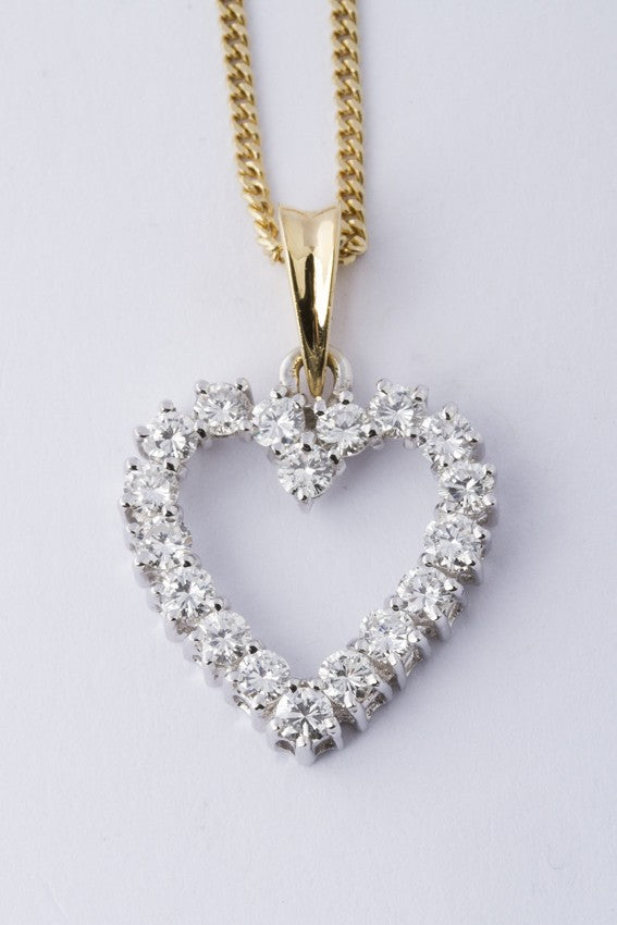 Gold heart pendant with diamonds on a gold necklace