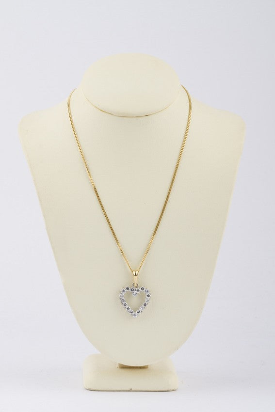 Gold heart pendant with diamonds on a gold necklace