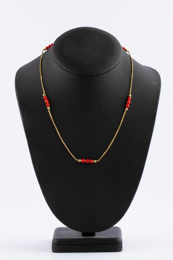 Gouden collier met bloedkoralen tussen schakels.