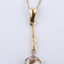 Gold solitaire pendant with a rose-cut diamond on a gold necklace