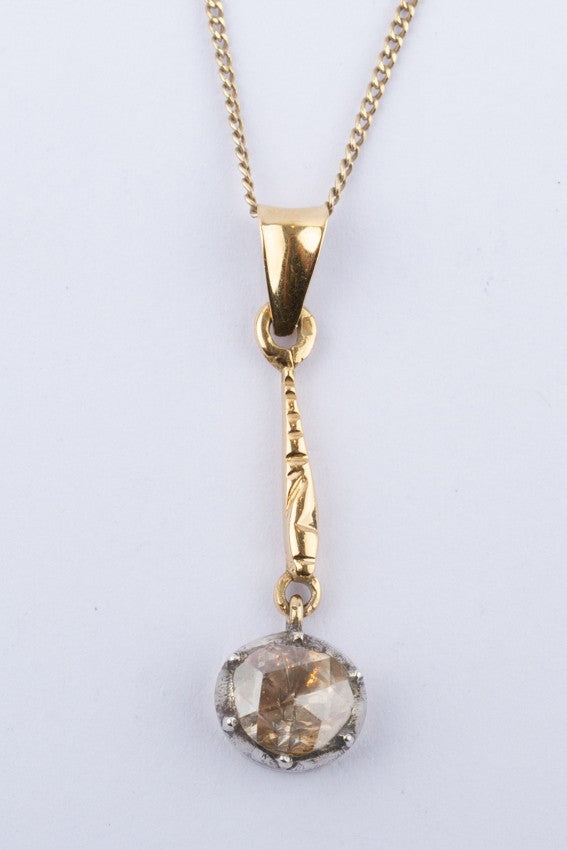 Gold solitaire pendant with a rose-cut diamond on a gold necklace