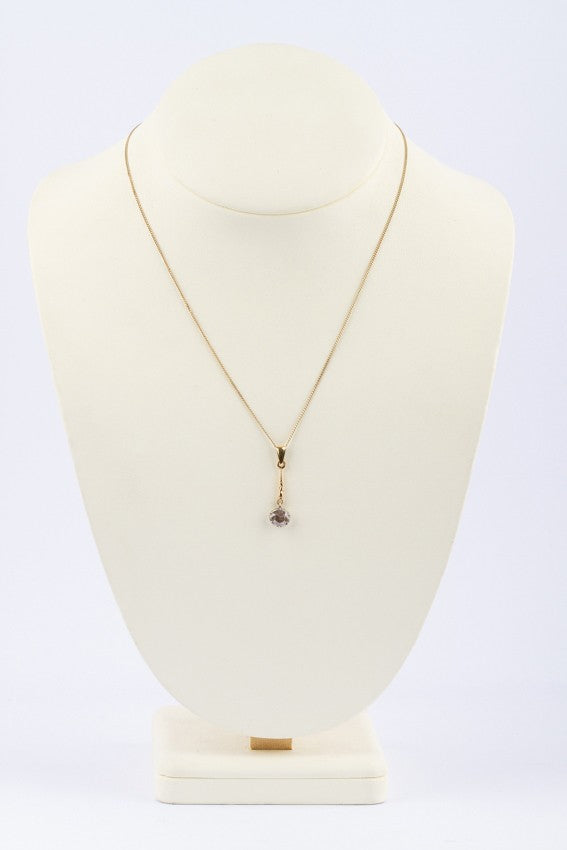 Gold solitaire pendant with a rose-cut diamond on a gold necklace