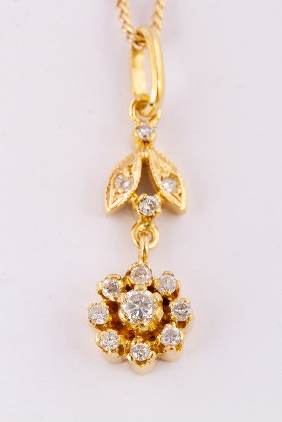 Gold entourage pendant with diamonds on a gold necklace