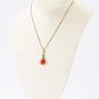 Gouden hanger met bloedkoraal aan gouden collier.