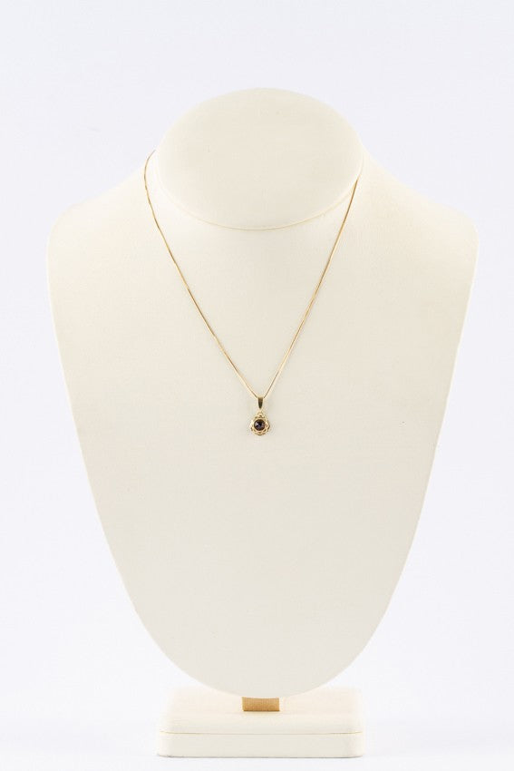 Gold pendant with garnet on gold necklace