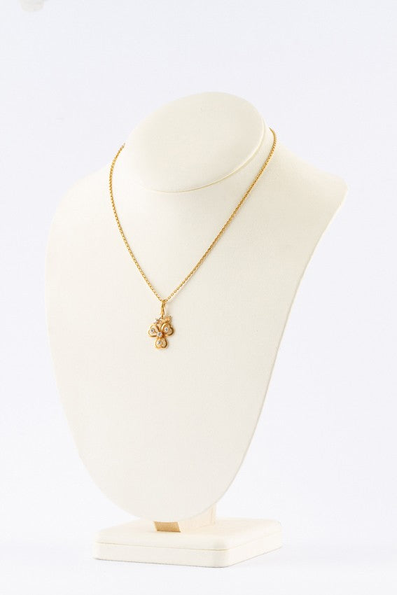 Gold three-leaf clover pendant with diamonds on a gold necklace