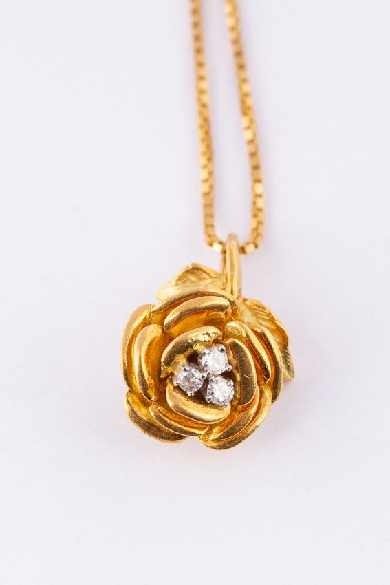 Gold rose pendant with 3 diamonds on a gold necklace