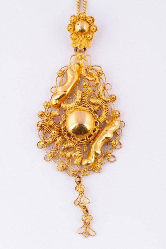Gold traditional costume pendant on gold necklace