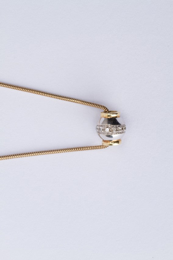 White/yellow gold pendant set with diamonds on a gold necklace