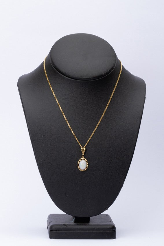 Gouden hanger met melk opaal aan gouden collier