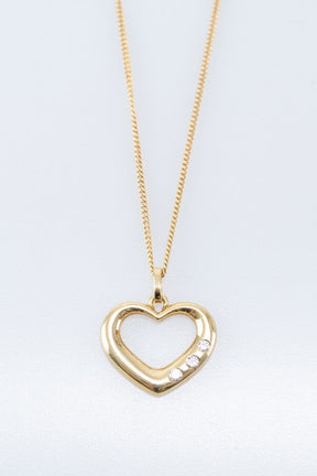 Gold heart pendant with diamonds on a gold necklace