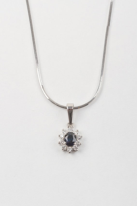 White gold entourage pendant with sapphire and brilliant cut diamonds on a white gold necklace