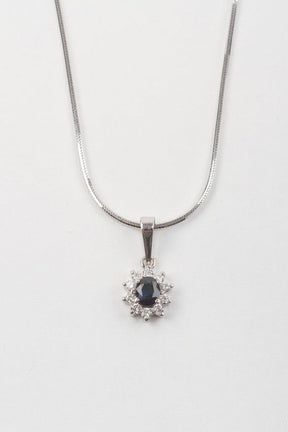 White gold entourage pendant with sapphire and brilliant cut diamonds on a white gold necklace