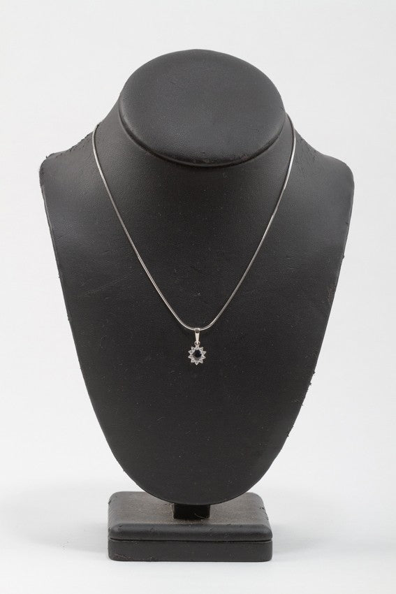 White gold entourage pendant with sapphire and brilliant cut diamonds on a white gold necklace